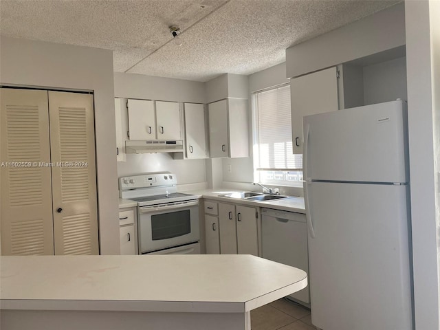 kitchen featuring a textured ceiling, white appliances, sink, light tile patterned floors, and white cabinets