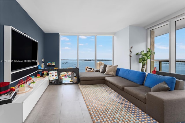 tiled living room featuring a wall of windows and a water view