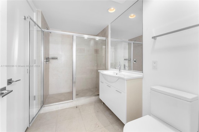 bathroom with tile floors, an enclosed shower, oversized vanity, and toilet