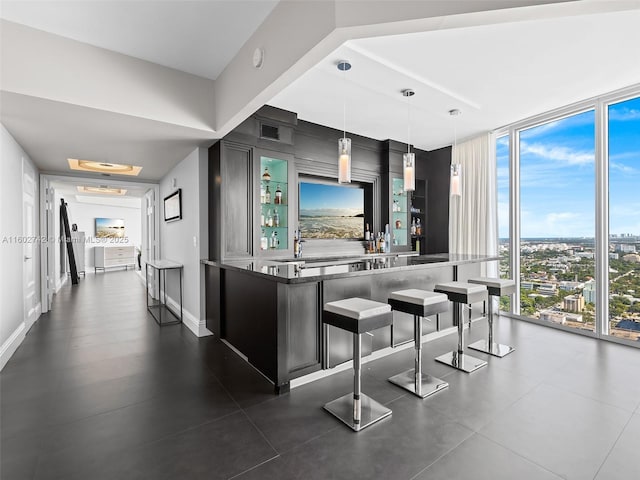 kitchen with pendant lighting, sink, a wall of windows, and a kitchen breakfast bar