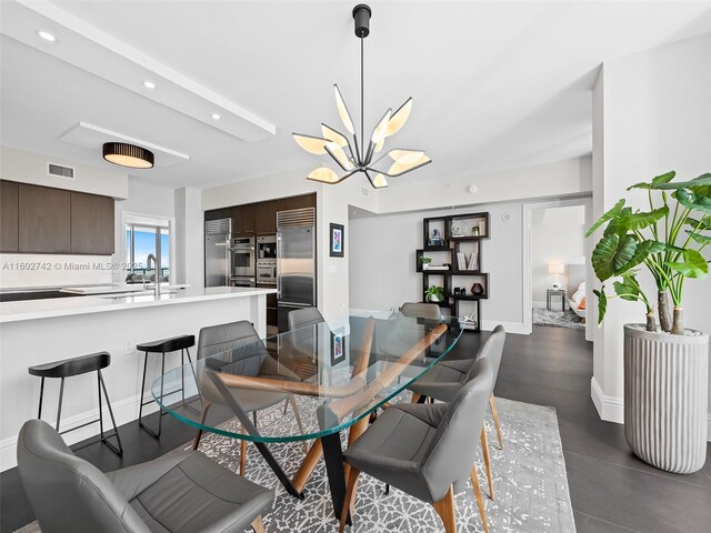 dining space featuring sink and a notable chandelier