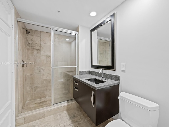 bathroom with vanity, a shower with shower door, and toilet