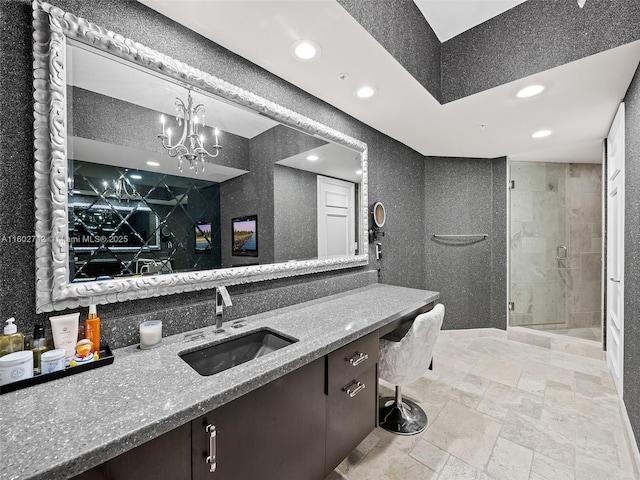 bathroom featuring a notable chandelier, vanity, and an enclosed shower