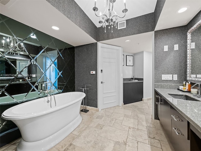 bathroom with a bathing tub, vanity, and a chandelier