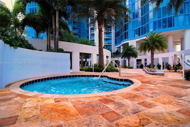 view of swimming pool featuring a hot tub and a patio