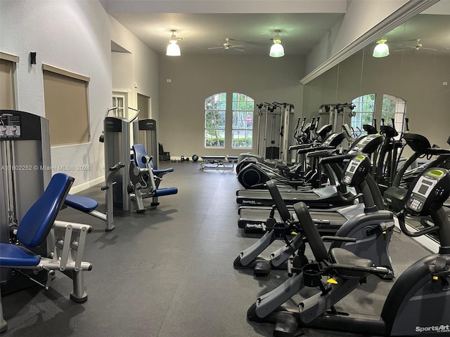 gym with a towering ceiling and ceiling fan