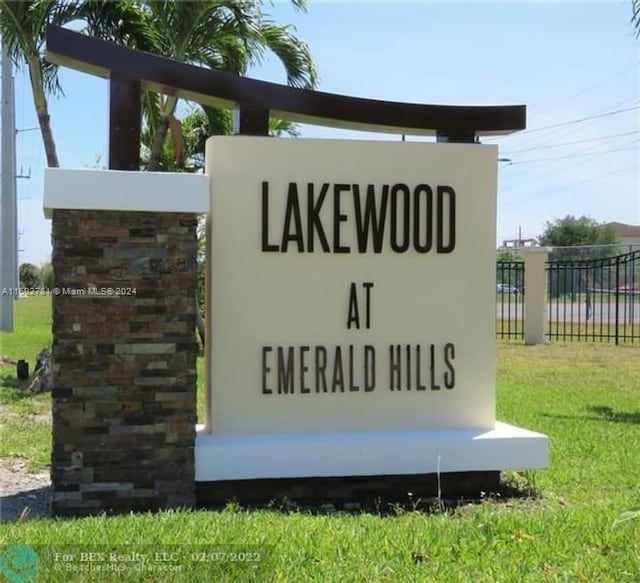 community sign featuring fence and a lawn