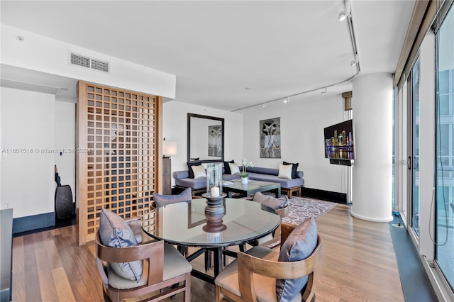 dining room with rail lighting and wood-type flooring