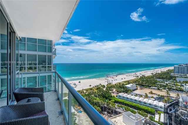 balcony featuring a view of the beach and a water view