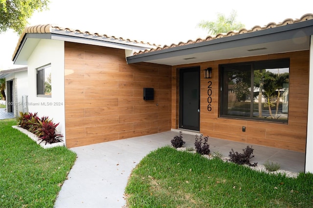 property entrance featuring a lawn