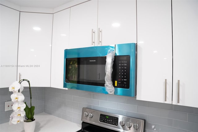 interior details featuring white cabinetry and backsplash