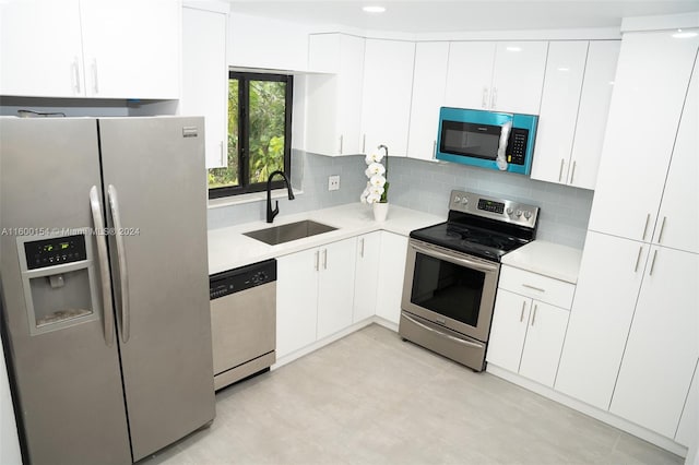 kitchen featuring appliances with stainless steel finishes, sink, tasteful backsplash, and white cabinetry