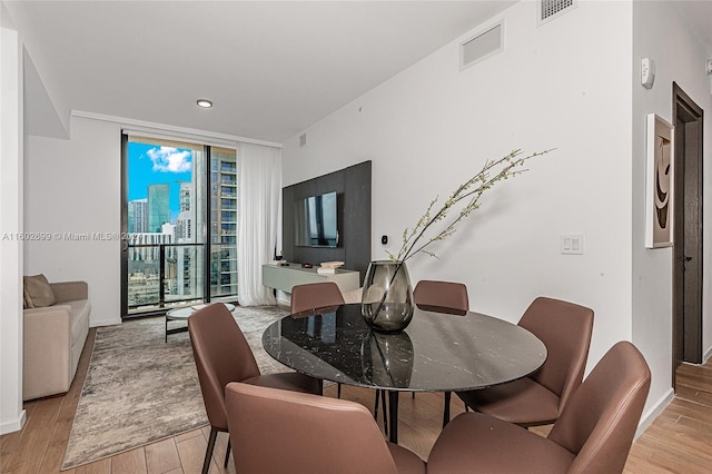 dining area with light hardwood / wood-style flooring and floor to ceiling windows