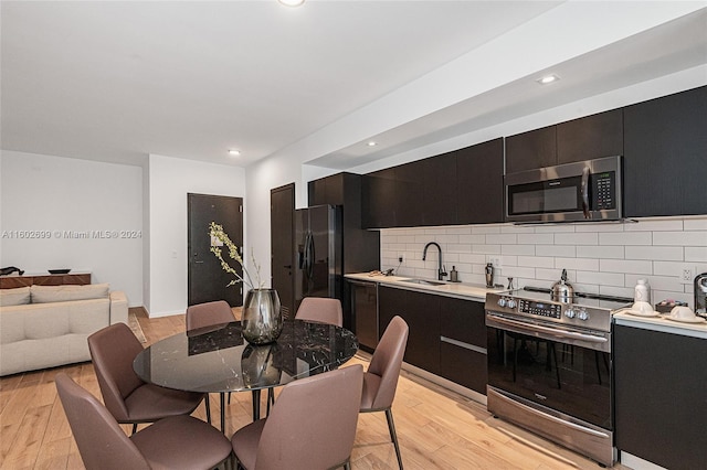 kitchen featuring light hardwood / wood-style floors, sink, backsplash, and stainless steel appliances