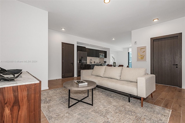 living room featuring sink and light hardwood / wood-style flooring