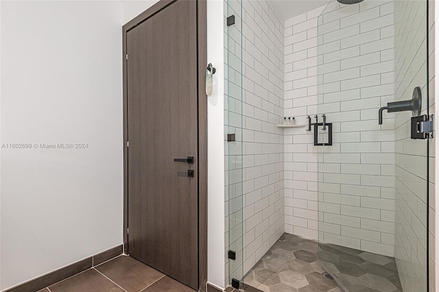 bathroom with a shower with shower door and tile patterned flooring