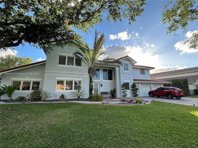 mediterranean / spanish-style home featuring a garage and a front yard