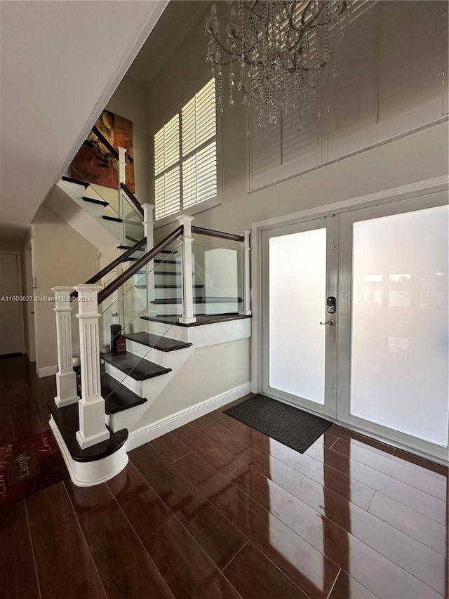 foyer entrance featuring a notable chandelier, french doors, a high ceiling, and dark hardwood / wood-style flooring