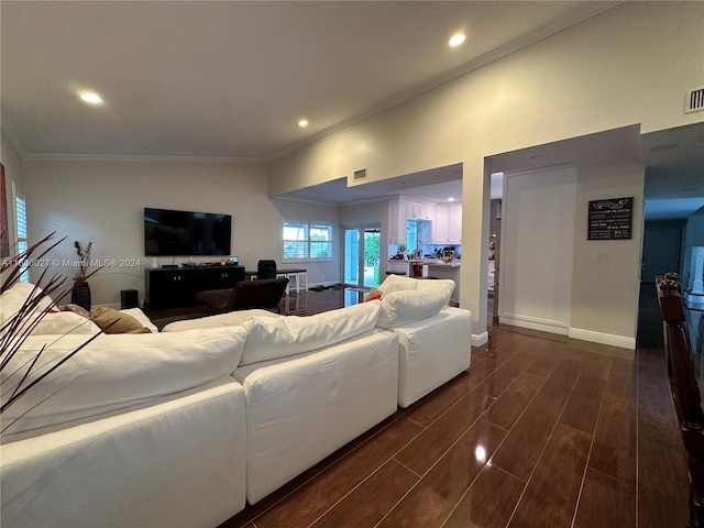 living room with ornamental molding, dark hardwood / wood-style floors, and vaulted ceiling