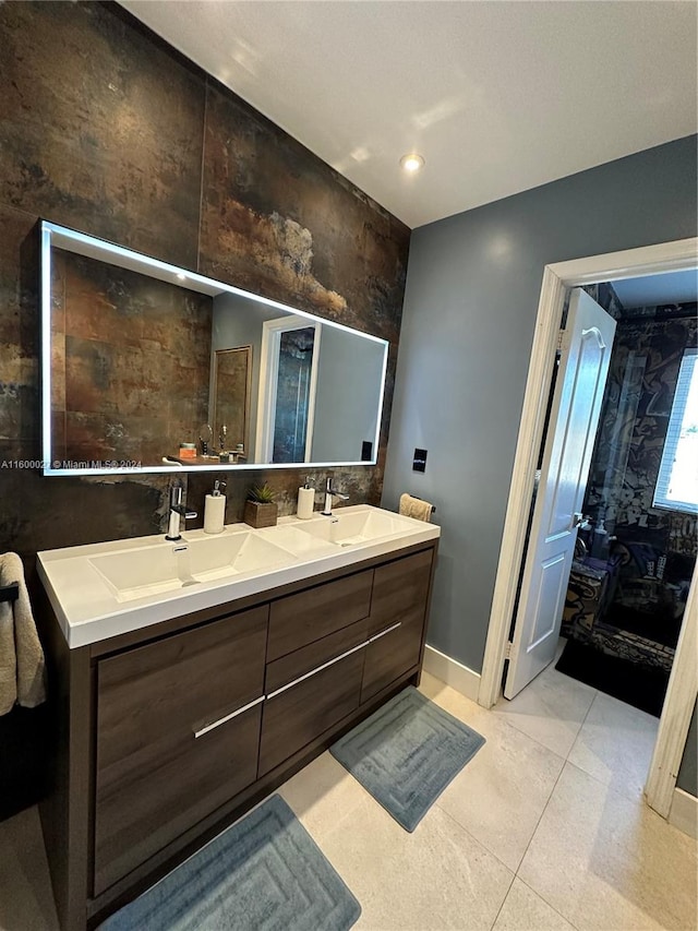 bathroom featuring tile floors, dual sinks, and vanity with extensive cabinet space