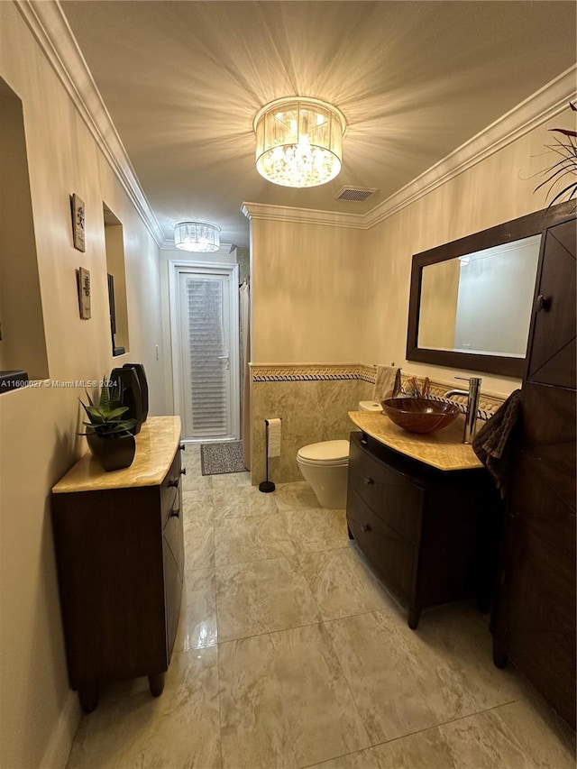 bathroom featuring tile flooring, vanity, toilet, and ornamental molding