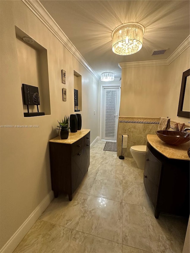 hallway featuring ornamental molding, an inviting chandelier, sink, and light tile floors