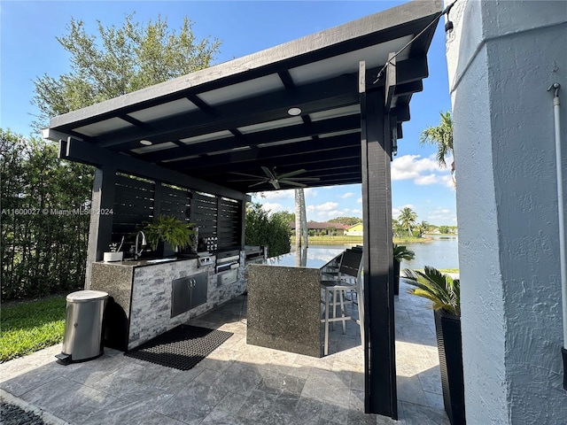 view of terrace featuring sink, a water view, and area for grilling