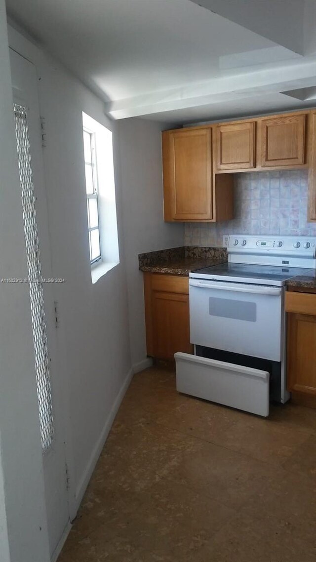 kitchen featuring backsplash and white electric range oven