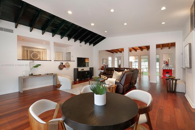 dining area featuring lofted ceiling with beams and dark hardwood / wood-style floors