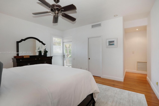 bedroom featuring light wood-type flooring, baseboards, ceiling fan, and visible vents
