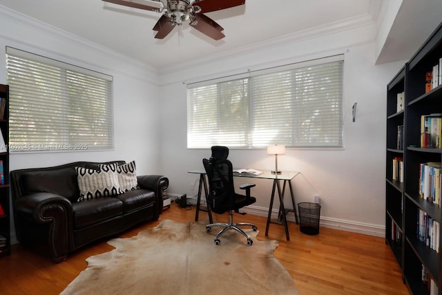 office area featuring wood finished floors, crown molding, baseboards, and ceiling fan