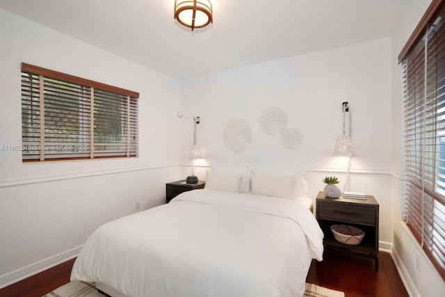 bedroom with baseboards and wood finished floors