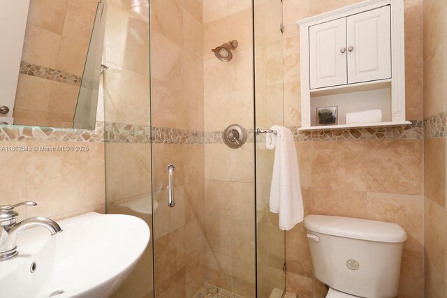 bathroom featuring vanity, toilet, an enclosed shower, and tile walls