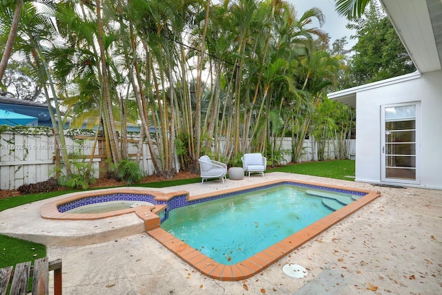 view of swimming pool featuring a patio, a fenced backyard, and an in ground hot tub