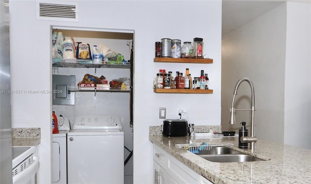 clothes washing area featuring separate washer and dryer and sink