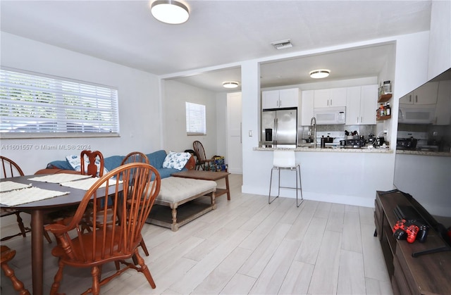 dining space featuring light wood-type flooring