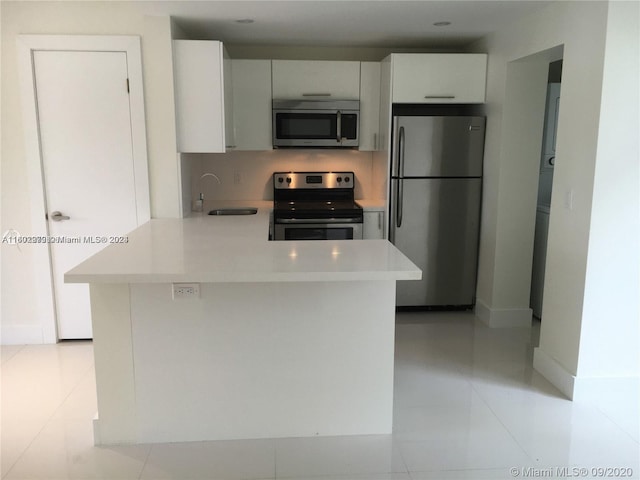 kitchen featuring light tile patterned floors, stainless steel appliances, white cabinetry, and sink