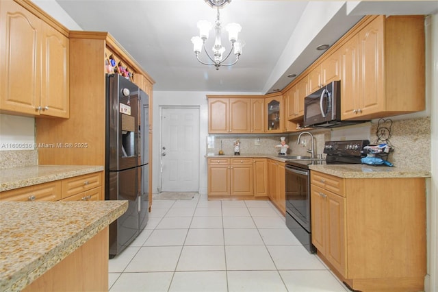 kitchen featuring light tile patterned floors, stainless steel appliances, light countertops, hanging light fixtures, and glass insert cabinets