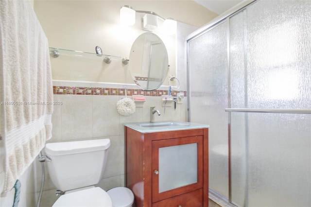 full bathroom with toilet, a shower stall, tile walls, and vanity