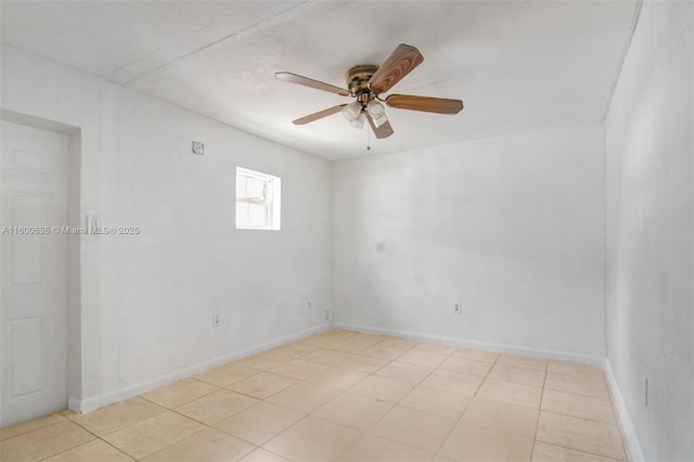 spare room with light tile patterned floors, baseboards, and a ceiling fan