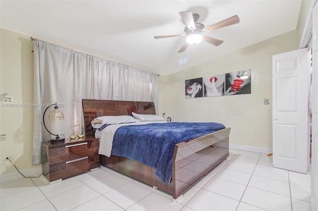 tiled bedroom featuring a ceiling fan and baseboards