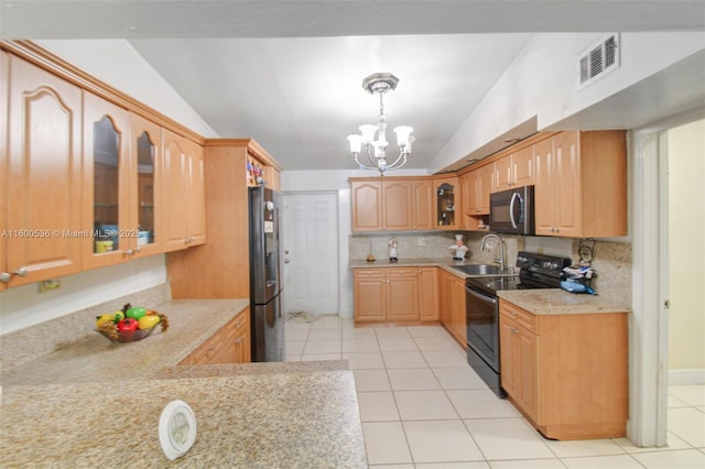 kitchen with visible vents, black appliances, a sink, an inviting chandelier, and light countertops