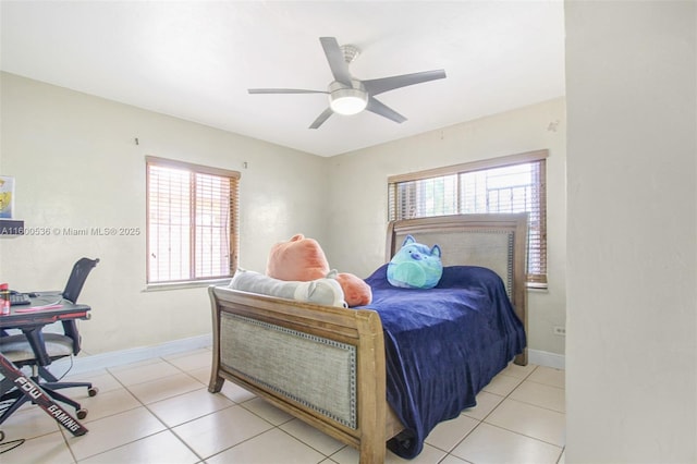 bedroom featuring light tile patterned flooring, multiple windows, and baseboards