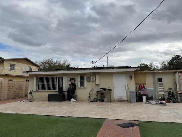 back of house featuring stucco siding, a patio, and fence