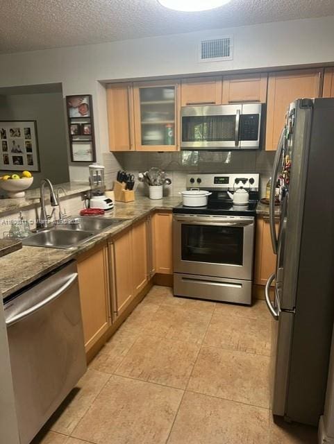 kitchen with kitchen peninsula, a textured ceiling, stainless steel appliances, and sink