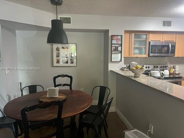 dining space with a textured ceiling