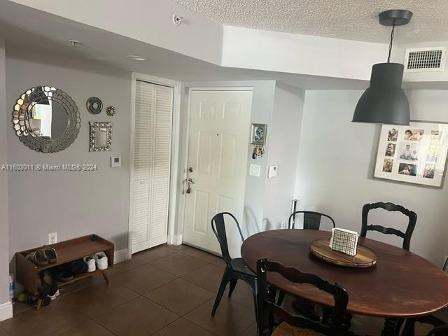 dining space with dark tile patterned floors and a textured ceiling