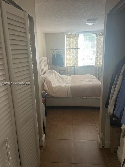 tiled bedroom featuring a textured ceiling