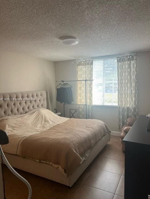 tiled bedroom featuring a textured ceiling