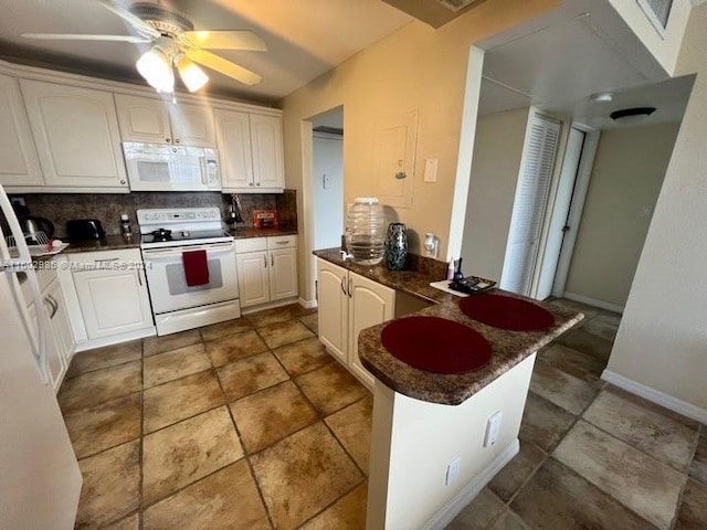 kitchen featuring kitchen peninsula, tasteful backsplash, white appliances, ceiling fan, and white cabinetry